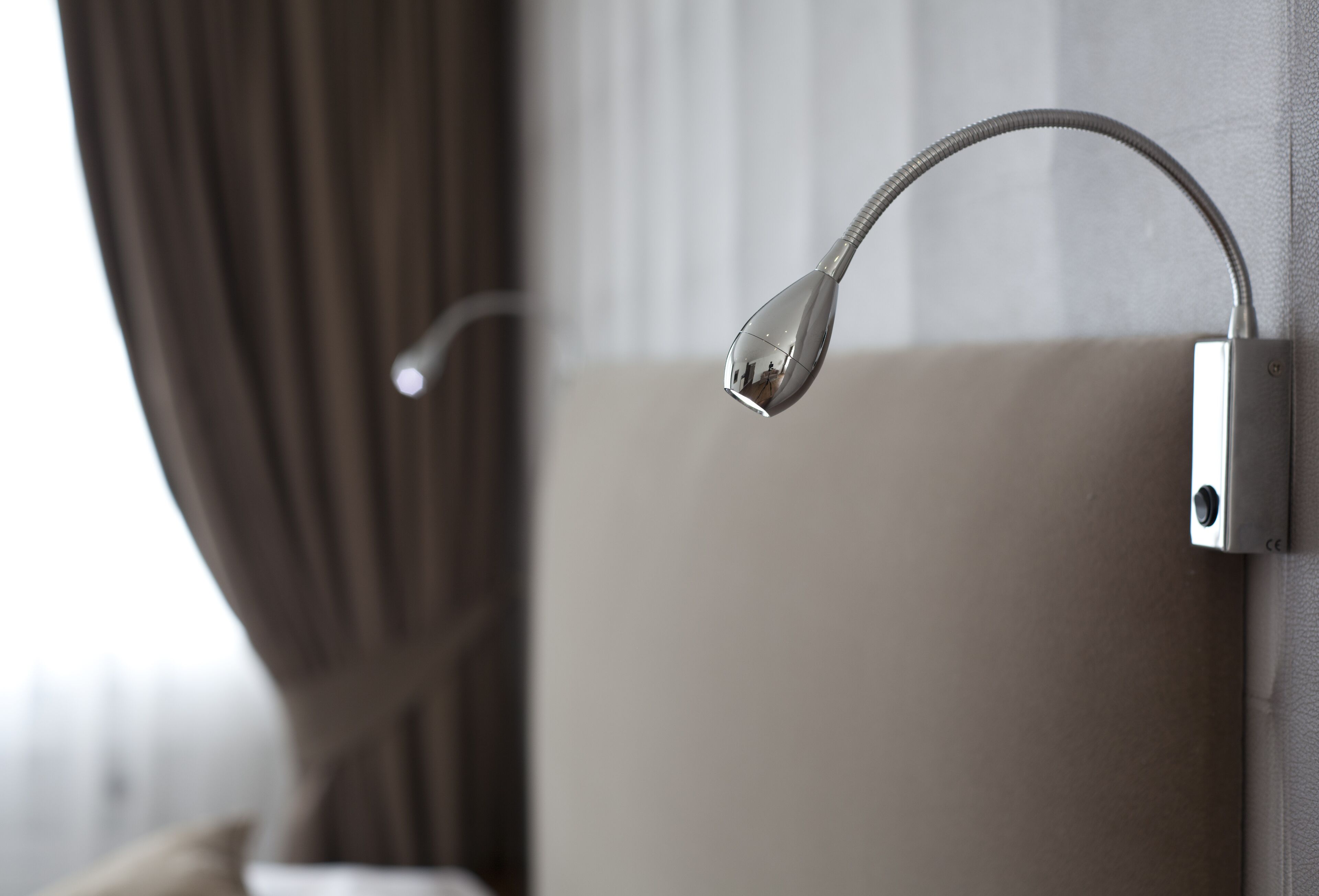 Une salle de bain moderne avec une pomme de douche fixée au mur et un porte-serviettes.