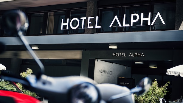 The exterior of Hotel Alpha with a sign indicating it houses an Alphabet Restaurant. - Hotel Alpha (Fribourg)