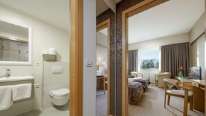 A hotel room with a bathroom, a bed, a desk, and a chair. - Hotel Zovko (Zagreb)