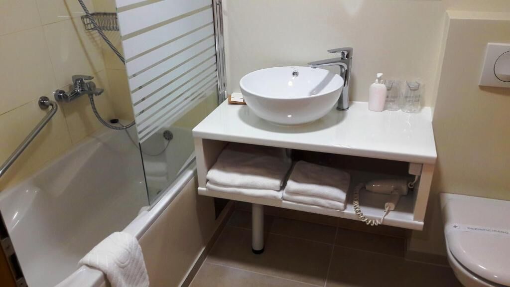 A bathroom with a white sink, a toilet, a bathtub, and a shower.