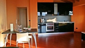 Una cocina moderna con armarios negros, una estufa de acero inoxidable y un techo de madera.