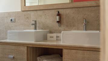 Un baño con dos lavamanos, un espejo y un perchero para toallas.