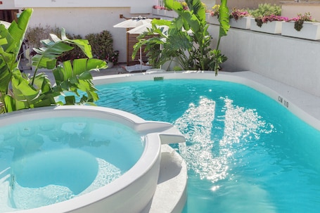 Una piscina al aire libre de temporada, sombrillas. Hotel Domomea