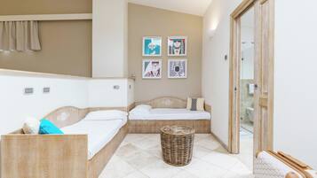 Ein modernes Hotelzimmer mit zwei Betten, einem Korbwäsches und Bildern an der Wand.