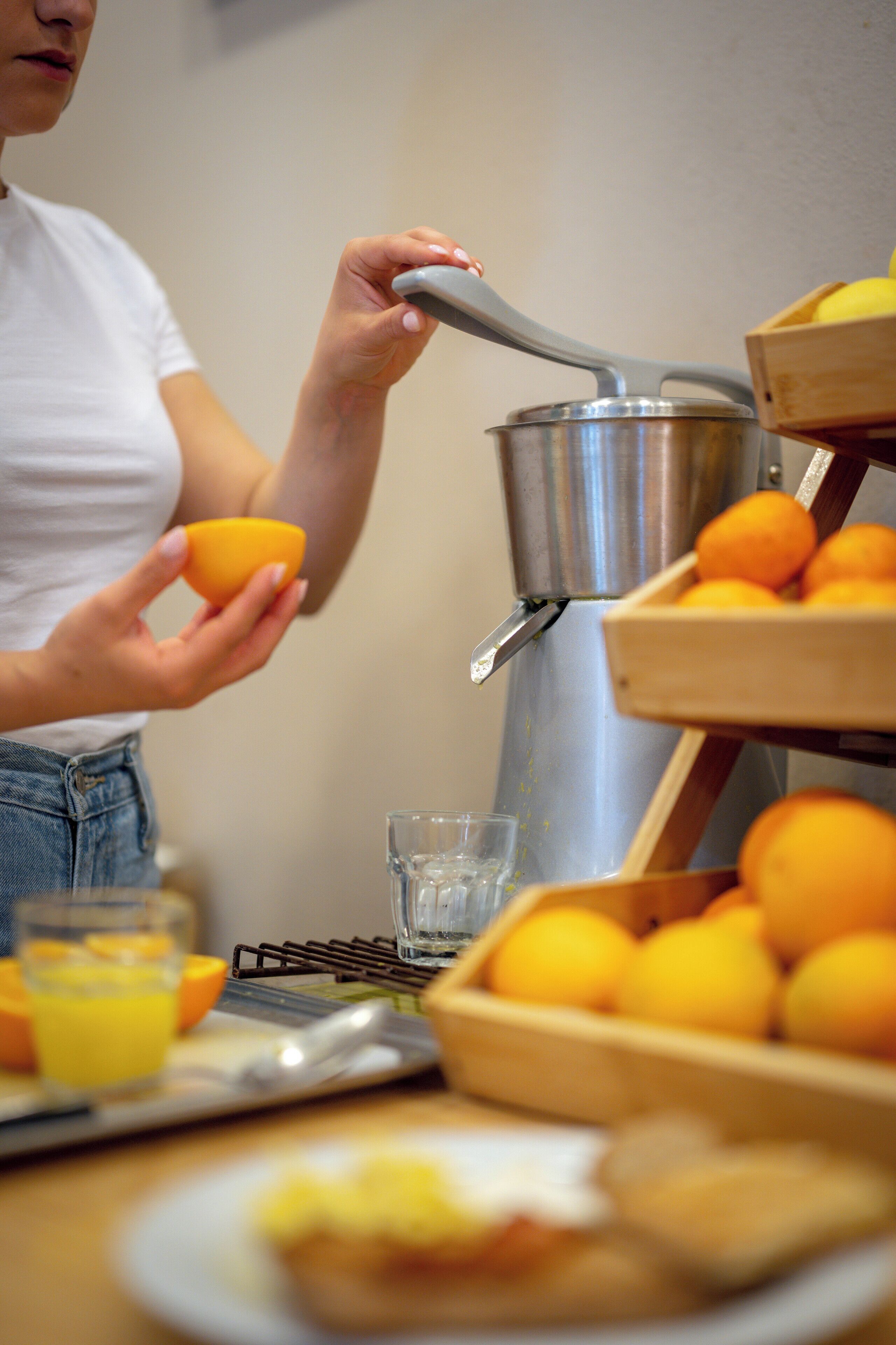 A person squeezing juice from an orange into a glass.