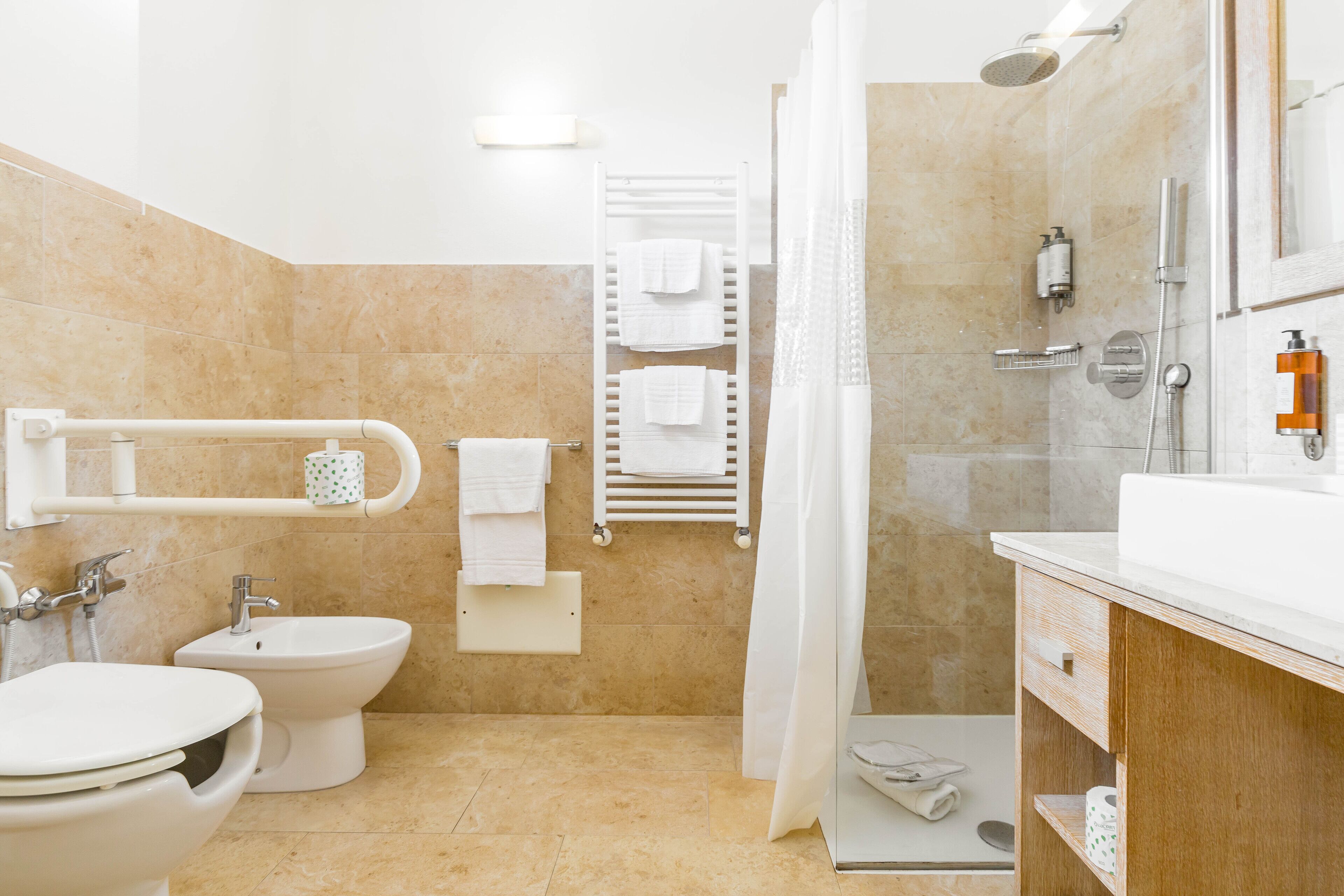 Une salle de bain moderne équipée de toilettes, d’un bidet et d’un espace douche.