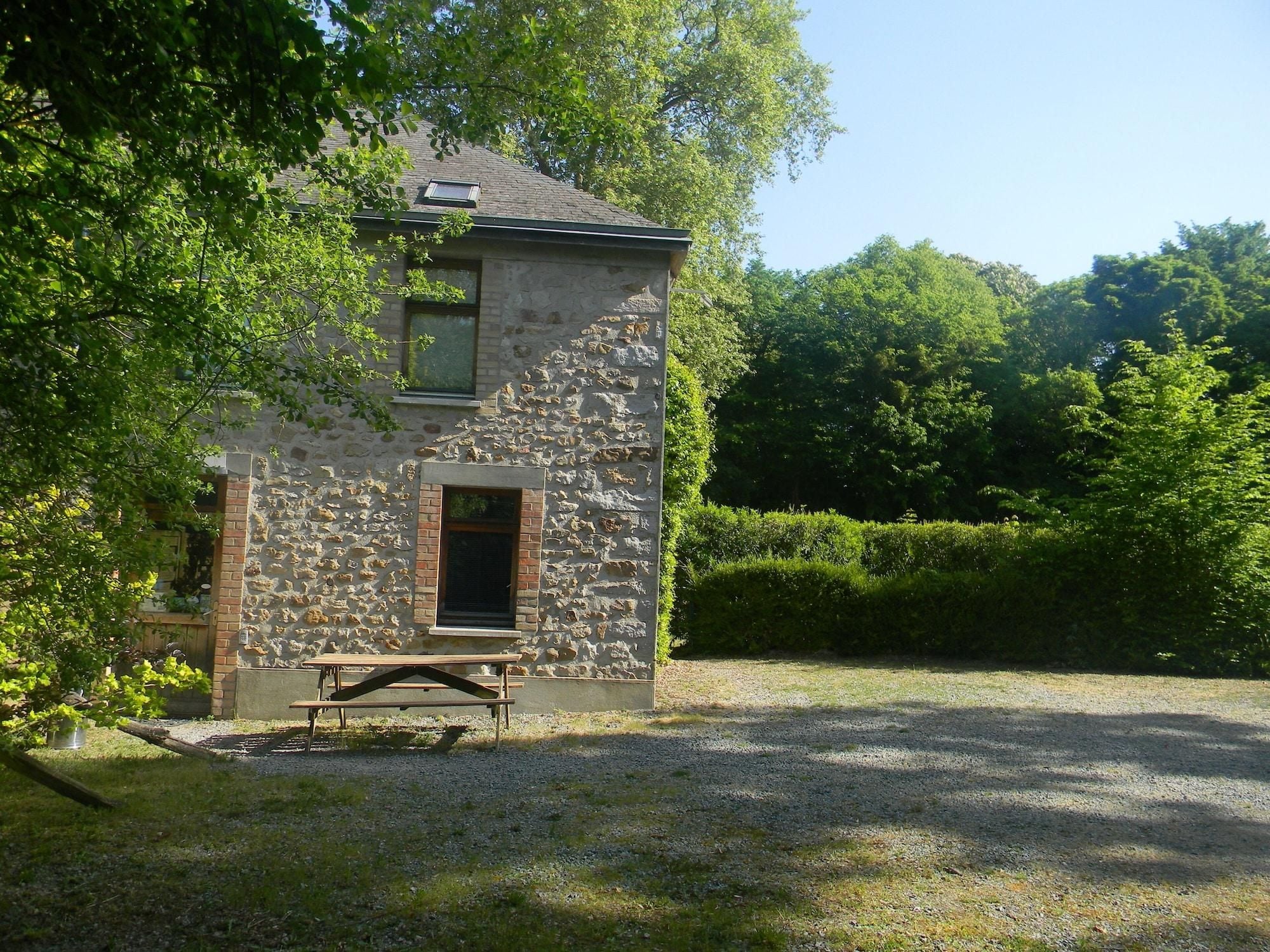 A stone building with a small window and a bench in front.