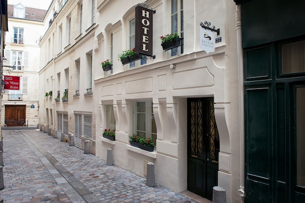 A hotel with a sign reading "HOTEL" and a plaque indicating the address "22 J. DE CLOS, 4TH DIRECTION".