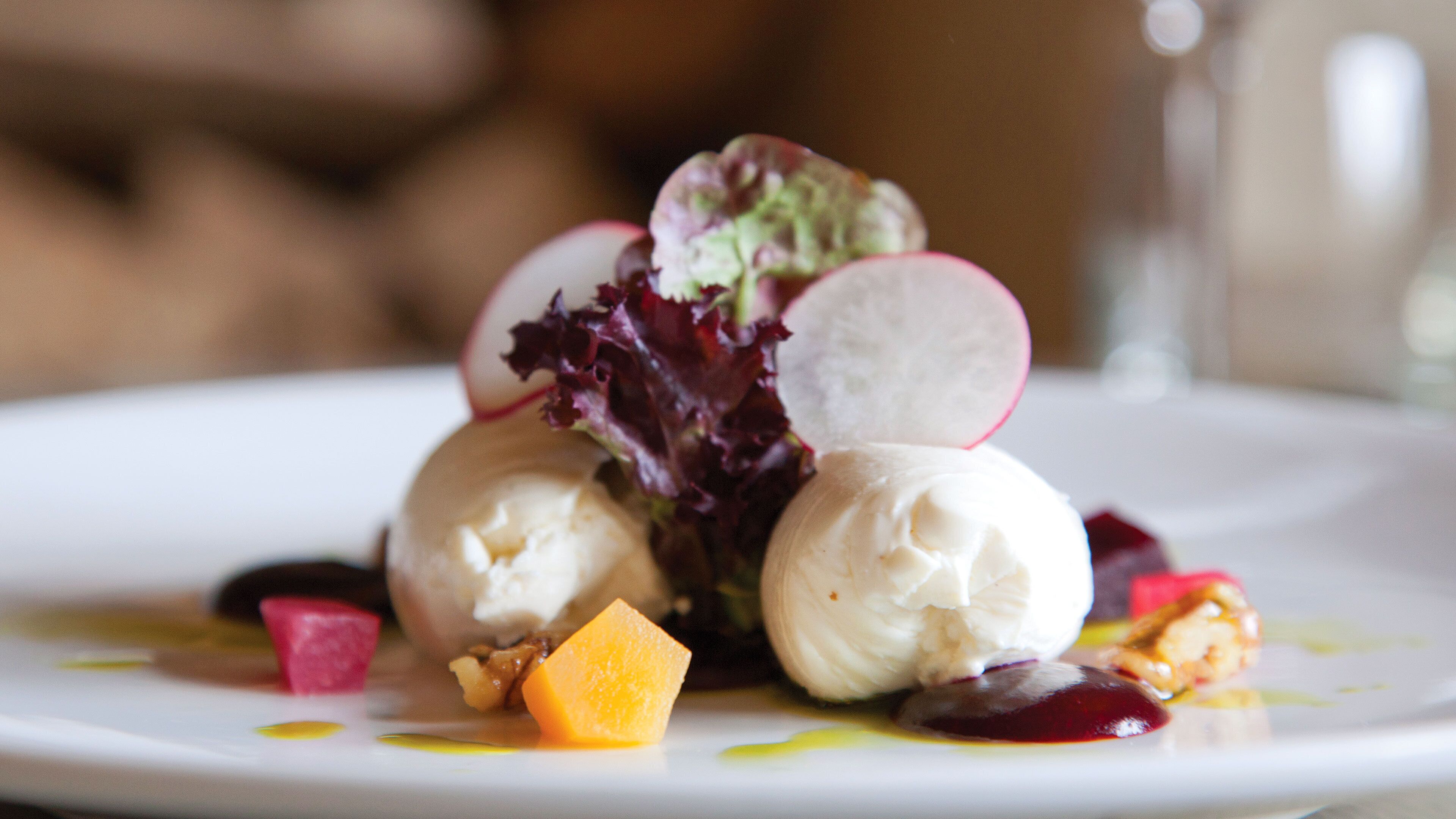 Un piattino con gelato, ravanelli e pezzi di frutta.