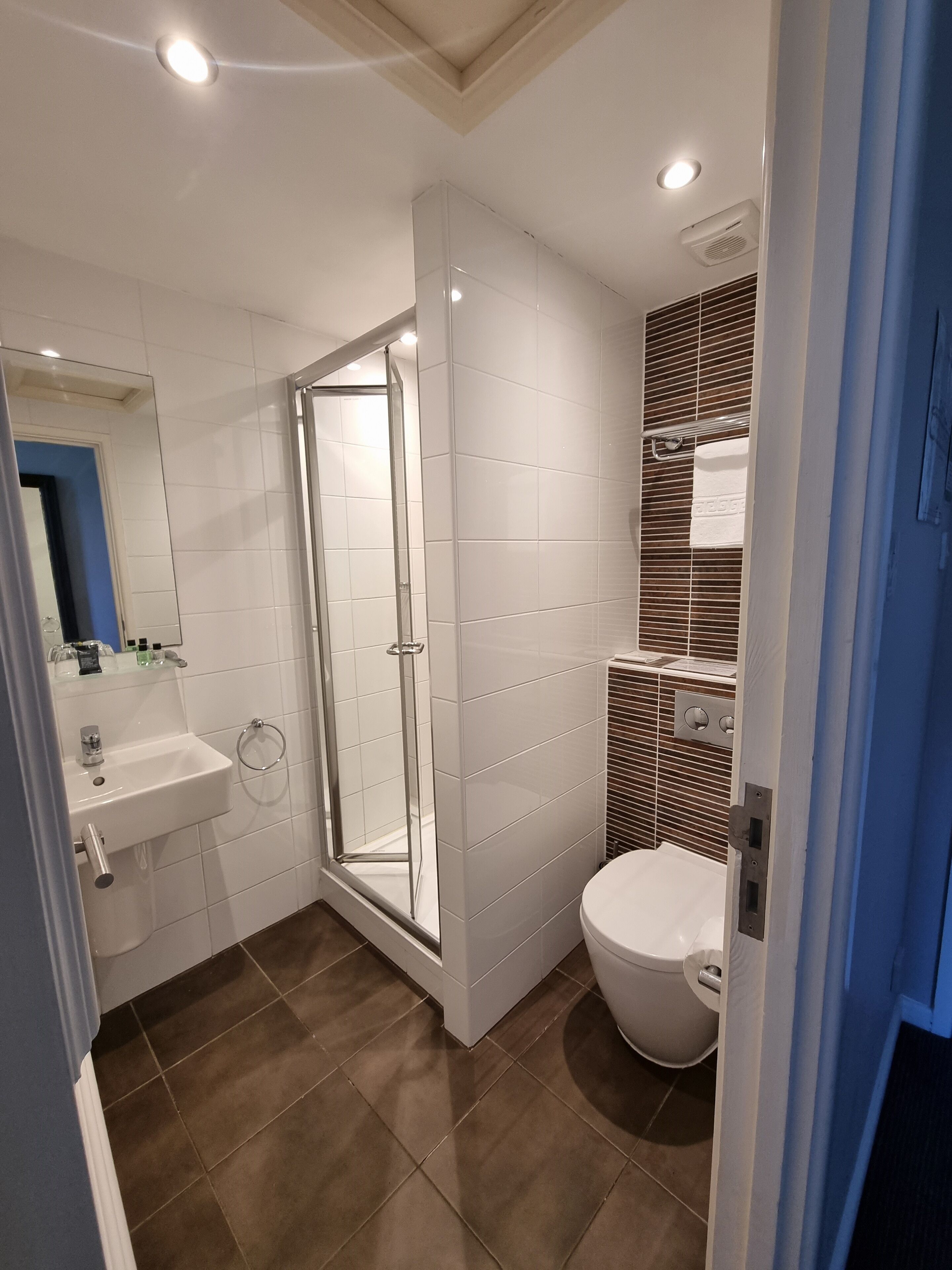 A modern bathroom with a shower, sink, and toilet.