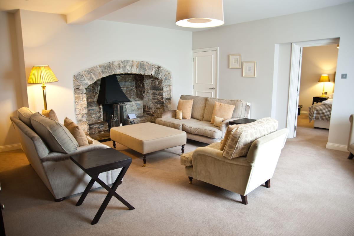 A living room with a stone fireplace, a sofa set, and a coffee table.