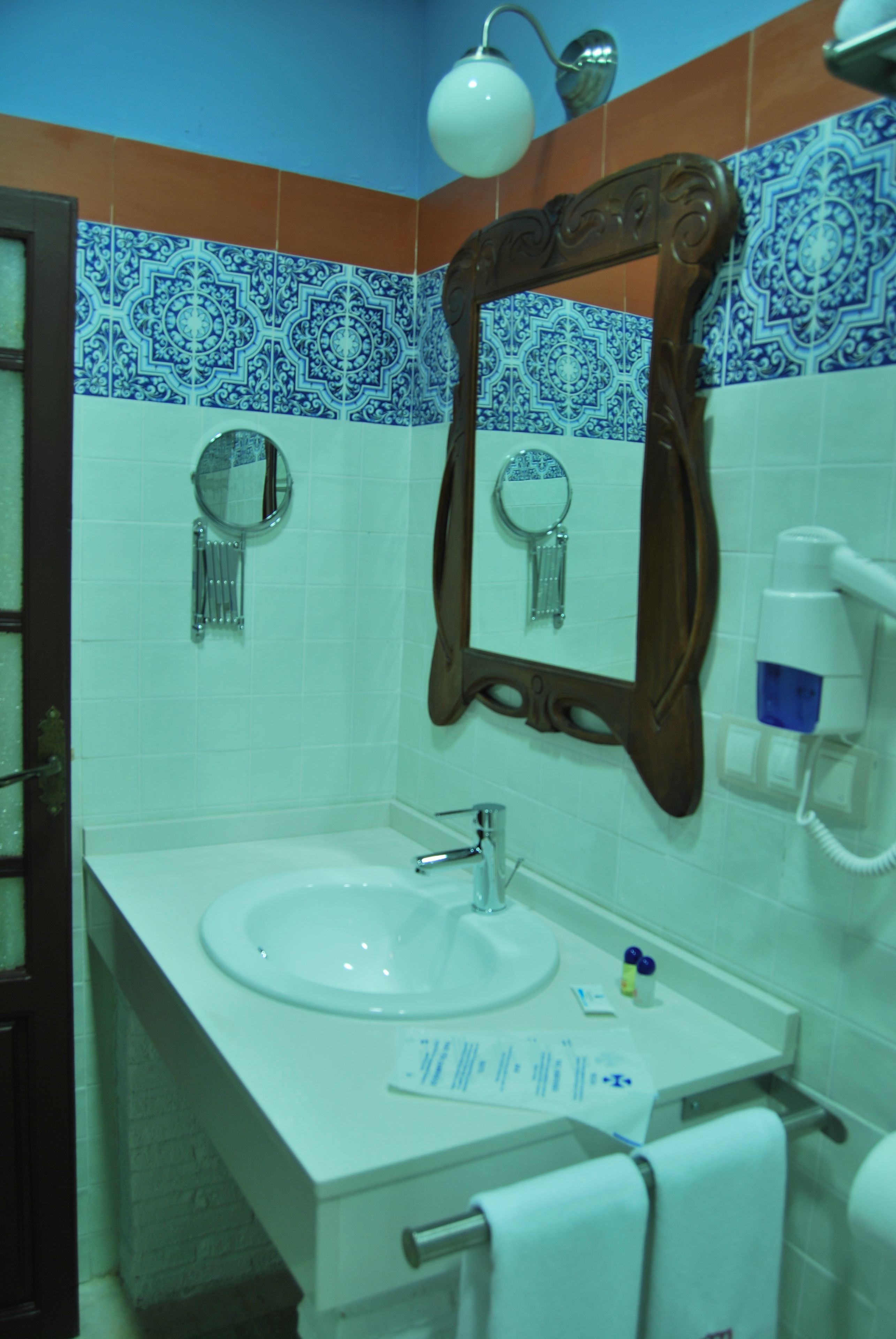 A bathroom with a white sink, a mirror, and a towel rack.