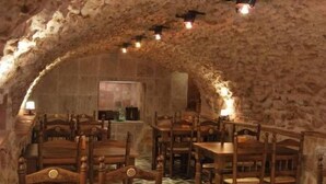 A rustic dining area with stone walls and wooden tables and chairs. - Hotel Rural Casa Grande Almagro (Almagro)