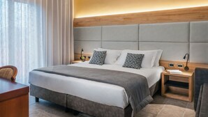 A modern hotel room with a large bed, a desk, and a chair. - Hotel La Fenice (Castel di Sangro)
