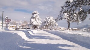 A snow-covered road with a sign for a restaurant and bar. - Hotel La Fenice (Castel di Sangro)
