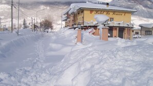 A snow-covered hotel named "Hotel La Fenice" with a visible sign indicating "Nice" and a "Pizzeria" sign. - Hotel La Fenice (Castel di Sangro)