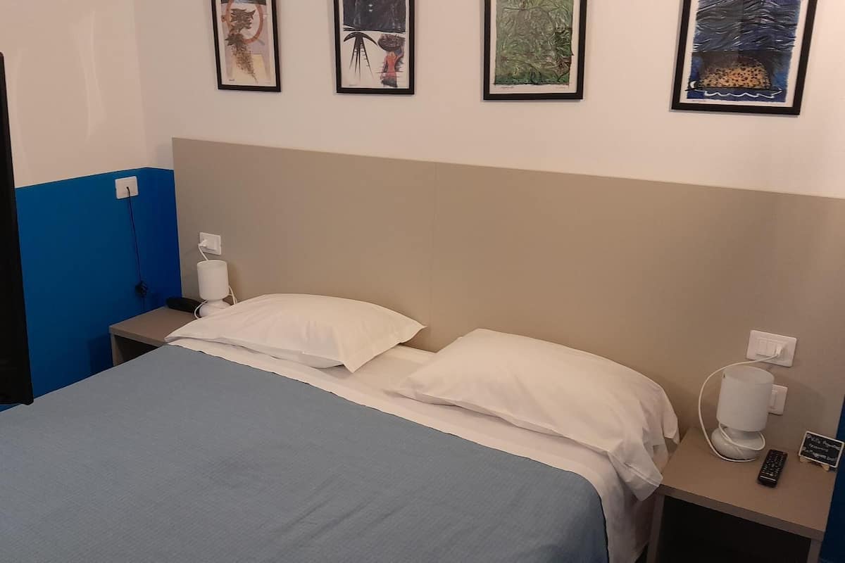 Economy kamer | Donsdekens, een bureau, een laptopwerkplek, beddengoed