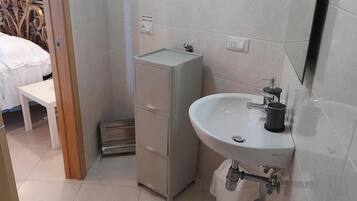 A bathroom with a sink, a mirror, and a cabinet.