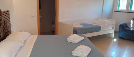 Habitación de hotel con dos camas, un baño y vistas al exterior.