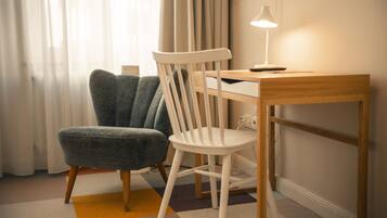 A room with a desk, a chair, and a lamp.