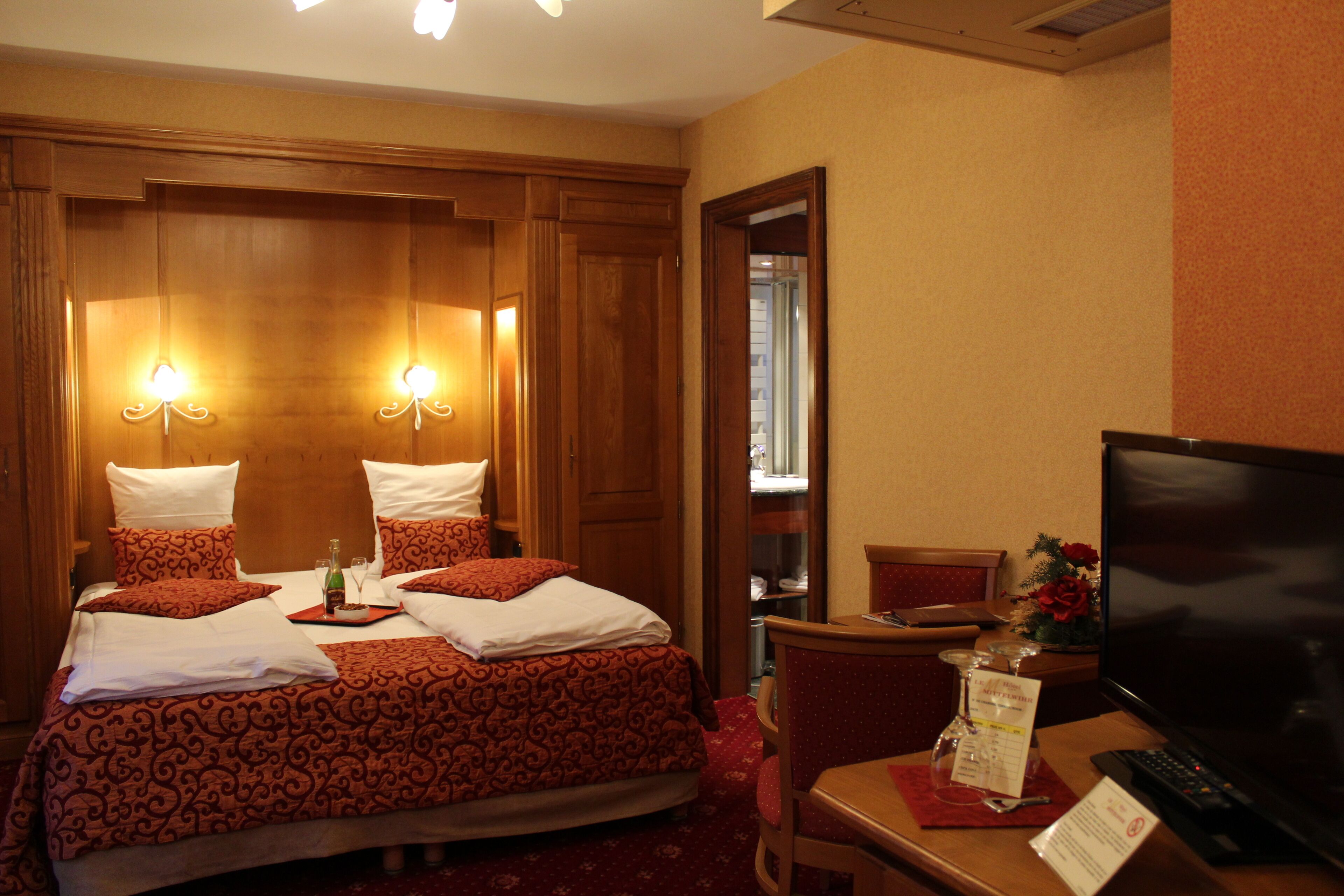 Une chambre d’hôtel avec un grand lit, un bureau avec un ordinateur et une télévision.