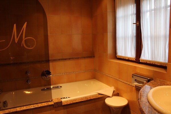 A bathroom with a bathtub, a toilet, and a sink.