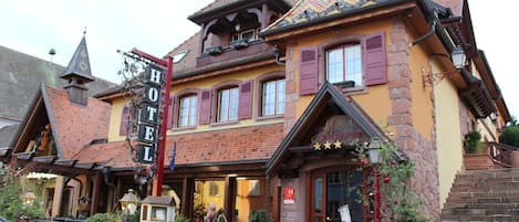 Ein traditionelles europäisches Hotel mit auffälligem Schild, Backsteinfassade und steilem Dach.