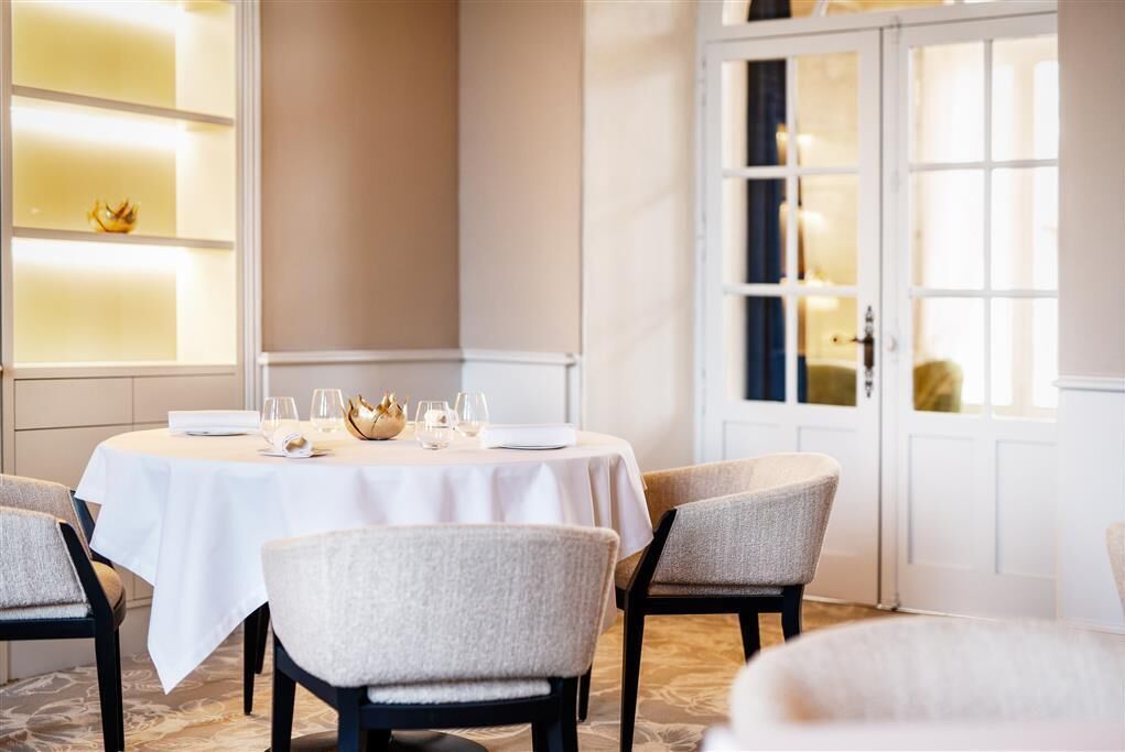Comedor con una mesa redonda para cuatro, sillas y un centro de mesa decorativo.