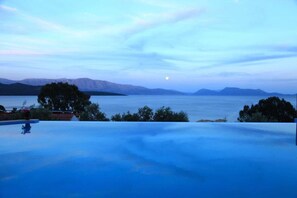 Una piscina con vista sulle montagne e su un lago.