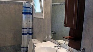 A bathroom with a toilet, sink, and shower. - La Casa Di Nonna Anna (Lefkada)