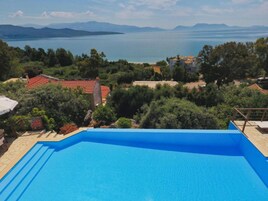 Una piscina con vistas a un lago y montañas al fondo.