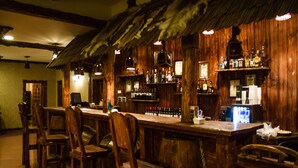 A bar area with wooden furniture and a long counter. - Dubai International Hotel (Baku)