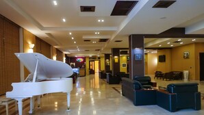 A spacious lobby with a grand piano, comfortable seating, and a bright, modern design. - Dubai International Hotel (Baku)