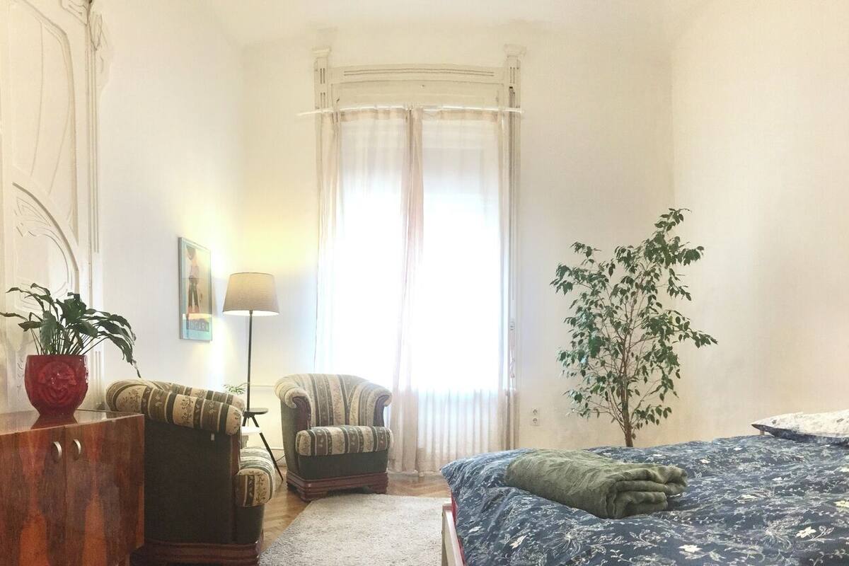A bedroom with a bed, bedside table, dresser, and a mirror.