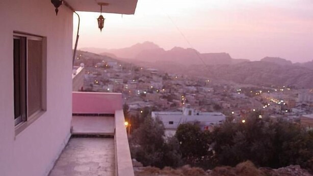 A balcony with a view of a cityscape at dusk. - Valentine Inn (Wadi Musa)