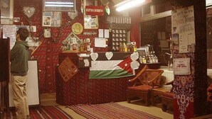 A hotel lobby with a reception desk, a flag, and various signs. - Valentine Inn (Wadi Musa)