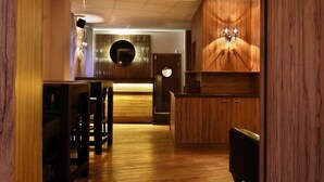 Una cocina moderna con armarios de madera, una isla central y un espejo redondo en la pared.