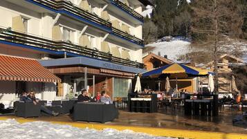 Un hotel con mesas al aire libre y un patio cubierto.