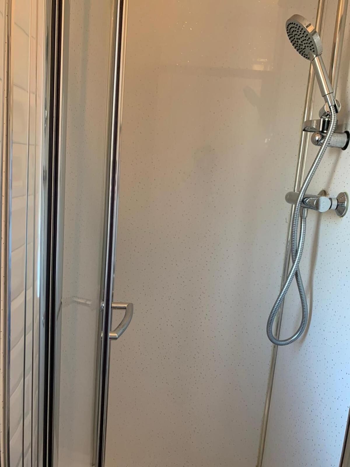 A shower with a handheld showerhead and a flexible hose.