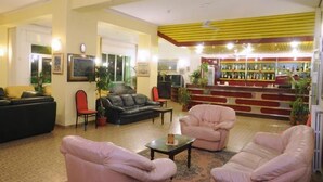 A hotel lobby with a bar area, sofas, and chairs. - Hotel Mondial (Praia a Mare)
