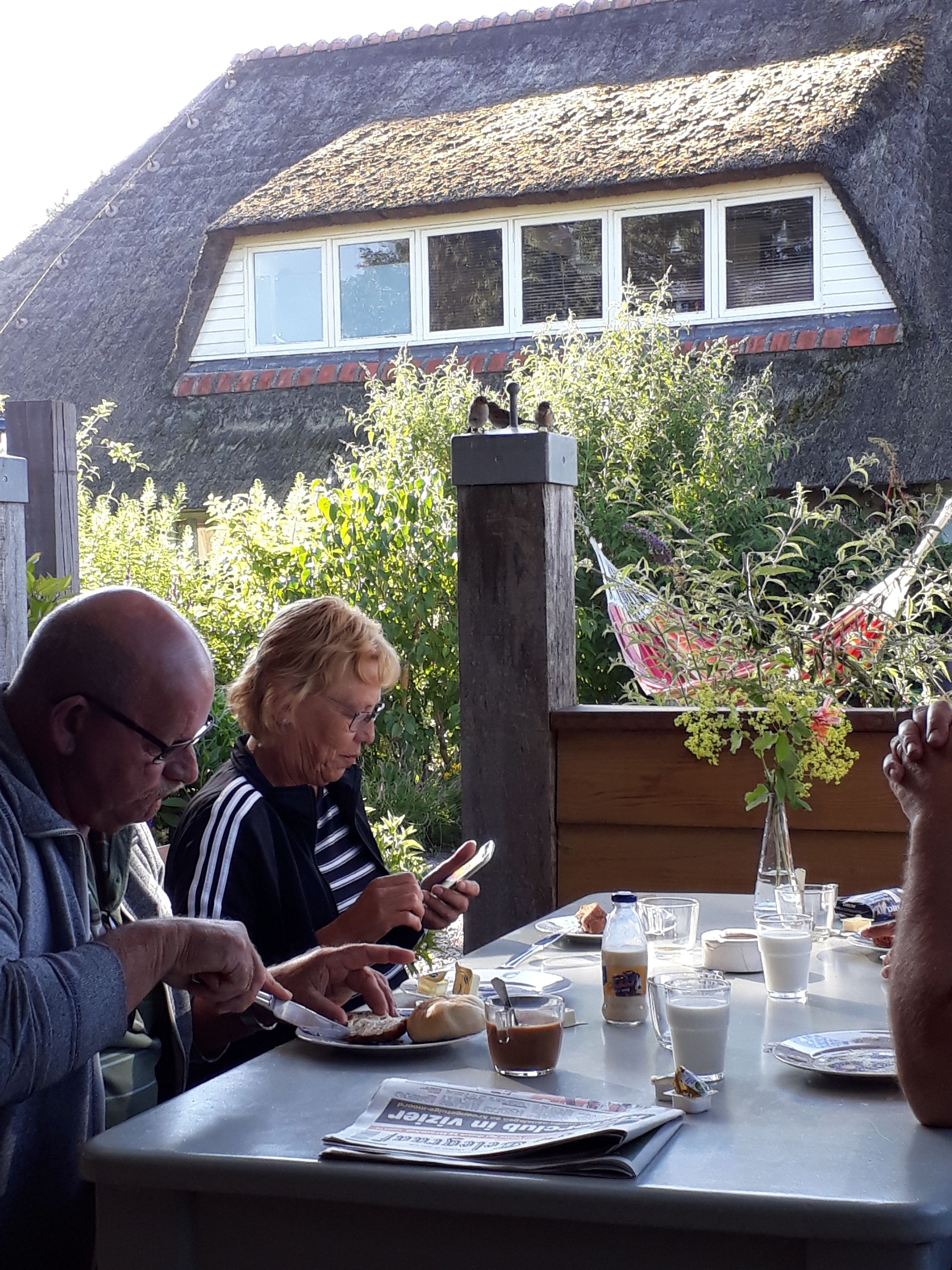 Et bord dækket udendørs med en bindingsværksbygning i baggrunden.