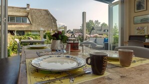 A dining table with a plate, mug, and a map placemat. - De Mariahoeve (Terherne)