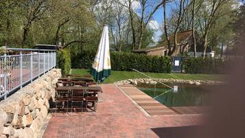 A patio area with picnic tables and a small pond.