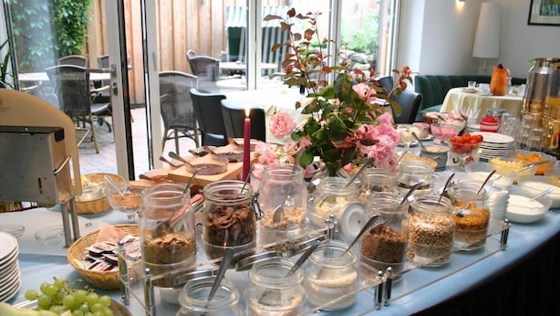 Une table de buffet garnie de divers plats et un vase rempli de fleurs.