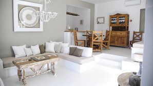 A modern living room with a sofa, coffee table, and dining area.