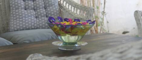 A glass bowl with colorful flowers on a wooden table.
