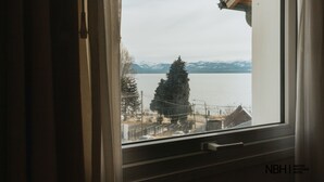 Une vue depuis une fenêtre d’un immeuble, avec une chaîne de montagnes en arrière-plan.