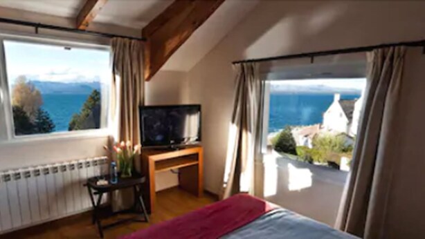 Une chambre avec un lit, une télévision et une vue sur la mer.