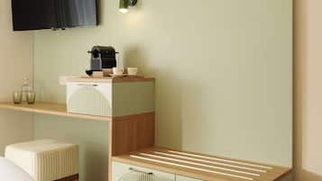 A bedroom with a bed, a desk with a coffee maker, a TV, and a wall-mounted shelf.