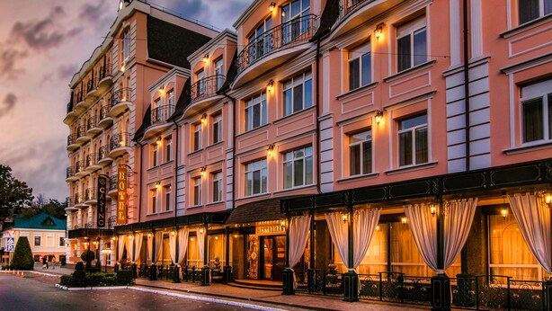 Un hotel de varios pisos con balcones, un casino y un restaurante.
